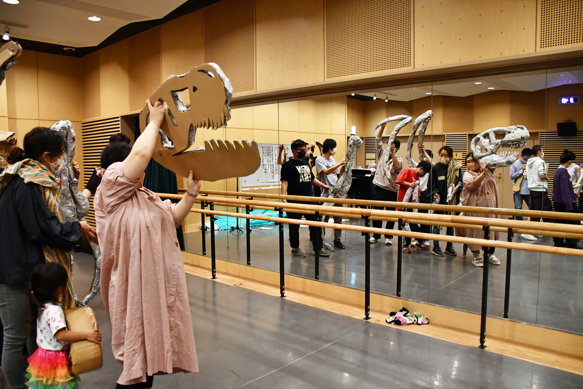 恐竜の骨を持って鏡の前に立つ